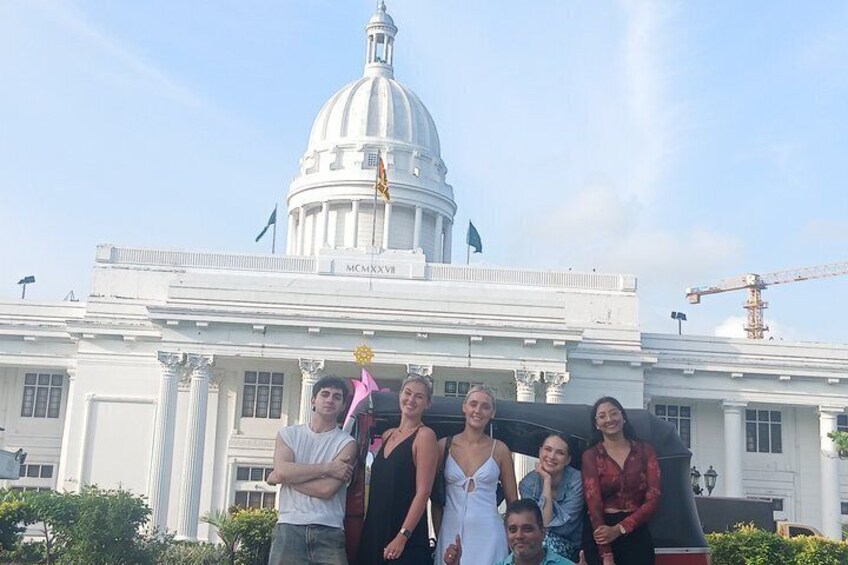 A group of people in front of a white building with a dome and columns. 3