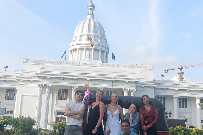 A group of people in front of a white building with a dome and columns. 3