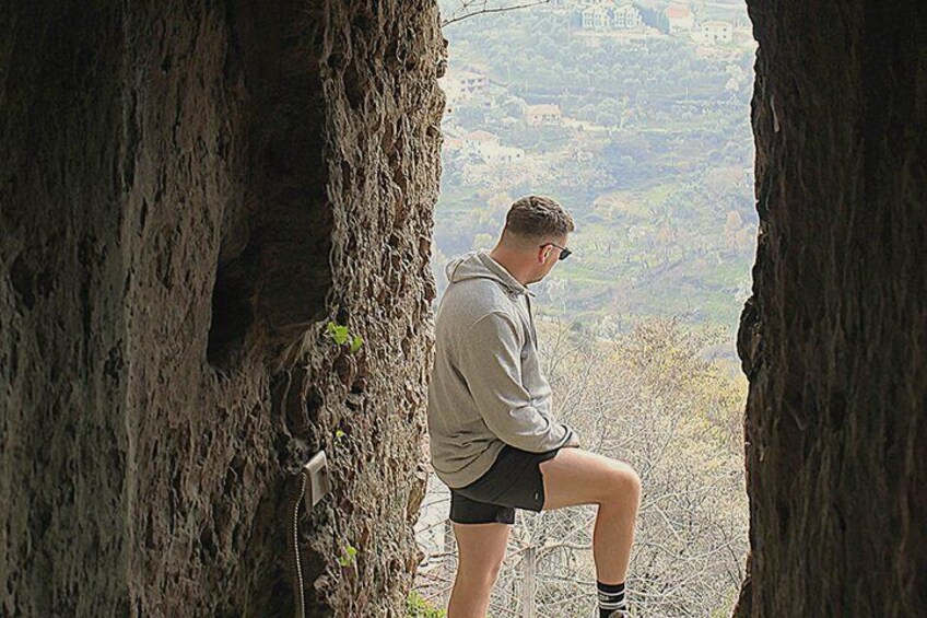 A person sitting on a rock, surrounded by trees, overlooking a valley. 5