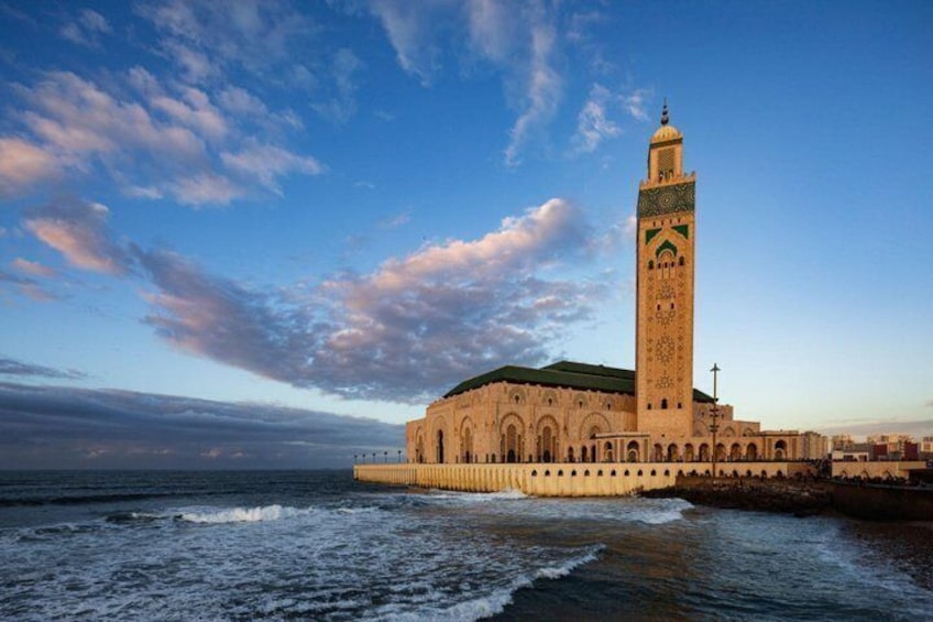 A coastal mosque with a tall minaret, surrounded by the sea. 1