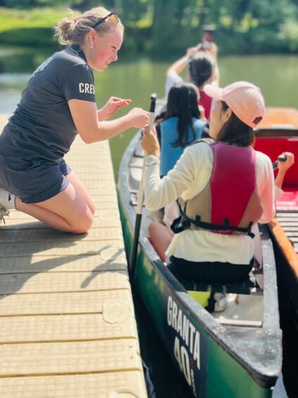 A person in a boat with 'GRANTA 40' written on it, another person in a boat, and a dock with a person kneeling on it. 3