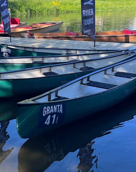 Several green paddle boats numbered GRANTA 41 and GRANTA 43 docked at a calm river. 1