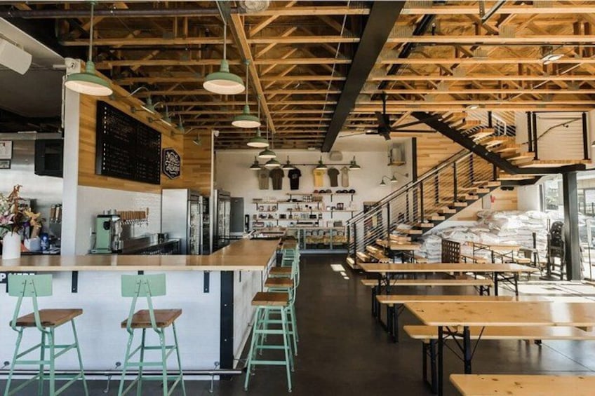 A cafe interior with wooden beams, green stools, and a bar area. 2