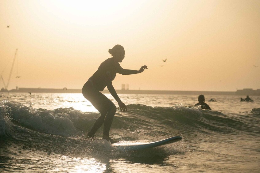 A person surfing on a wave during sunset. 5