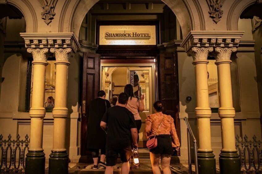 The entrance to Shamrock Hotel with columns and a sign. 3