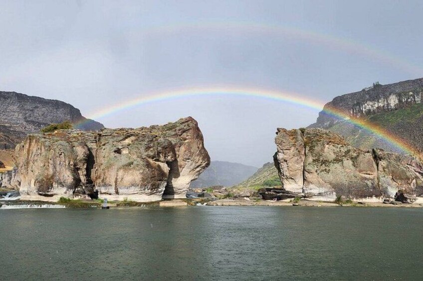 A river with rock formations and a rainbow. 3