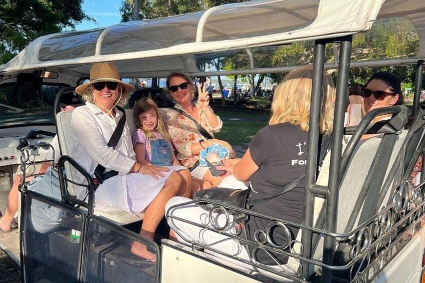 A group of people on a golf cart. 4