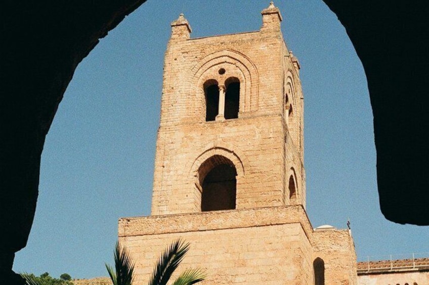 A stone tower with arched windows and a dome, framed by a natural arch. 5