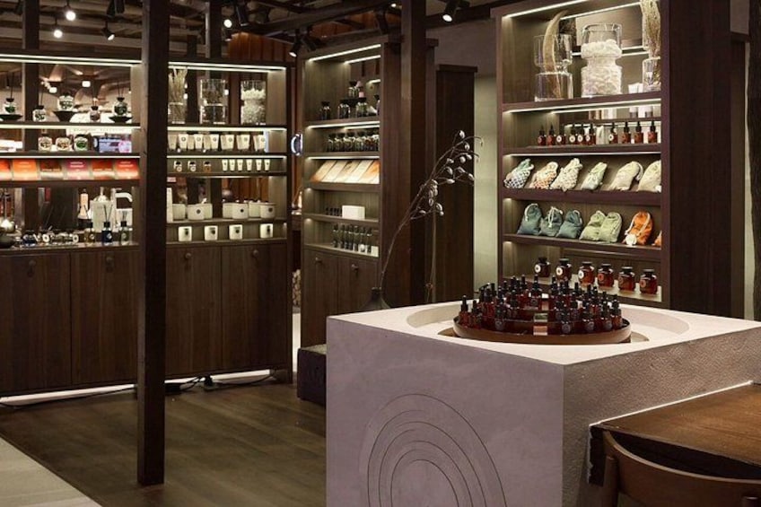 Interior de una tienda con estanterías de madera, una mesa de exhibición central y una variedad de productos. 2