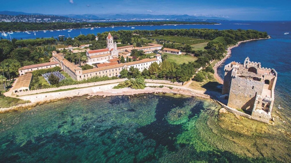 A coastal fortress with a tower, surrounded by clear waters and greenery. 4