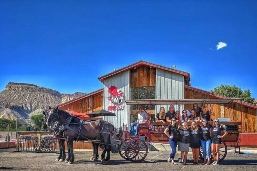 A group of people standing in front of a building with a horse-drawn carriage. 2