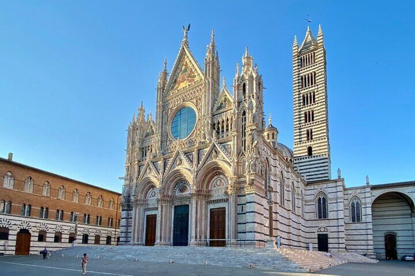 A grand cathedral with intricate Gothic architecture, a prominent bell tower, and a clear blue sky. 5