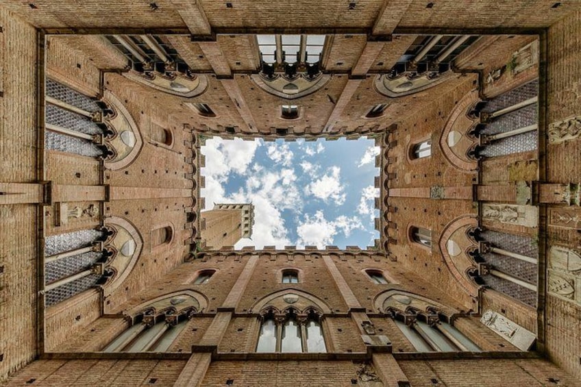A symmetrical architectural structure with arched windows and a central open space. 5