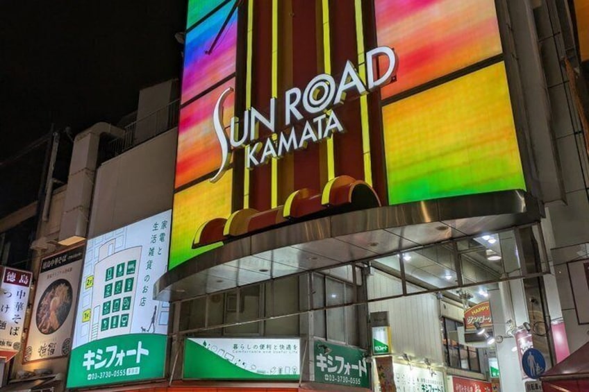 A brightly lit building with a colorful sign reading 'SUN ROAD KAMATA.' 4