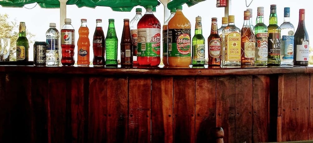 A variety of bottles and cans on a wooden bar counter. 3