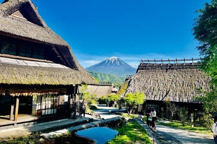 Traditional thatched-roof buildings, a clear blue sky, and a mountain in the background. 3