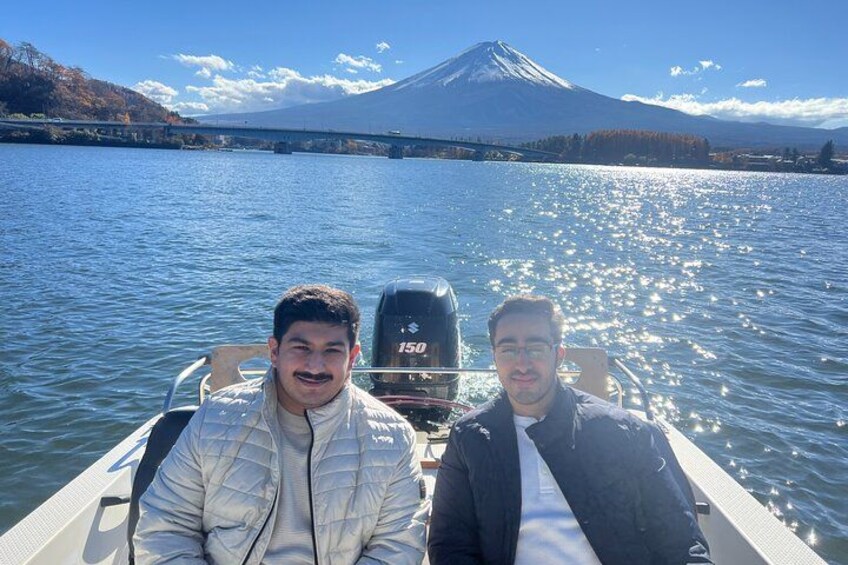 Two people on a boat with a mountain in the background. 3