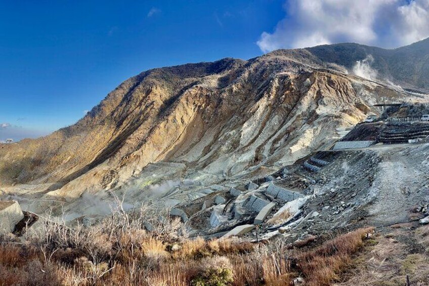 A rugged mountain landscape with exposed rock layers and a clear sky. 5