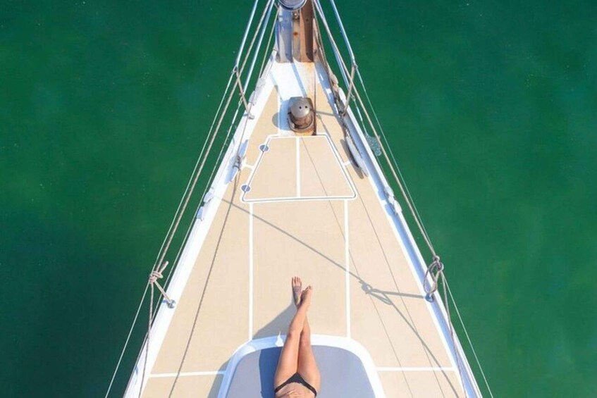 A person lying on a boat deck with a view of the water. 5