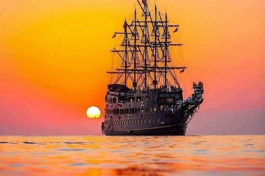A tall ship sailing at sunset with a warm sky and calm waters. 2