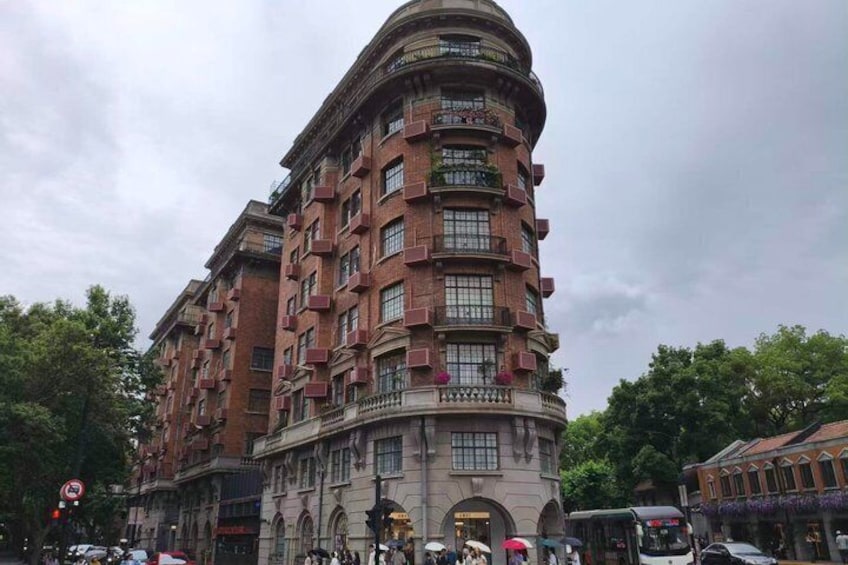 A multi-story building with a curved facade, large windows, and balconies. 1