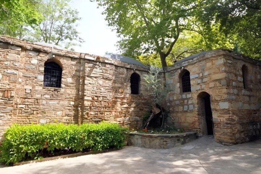 A stone building with arched windows and a fountain. 2