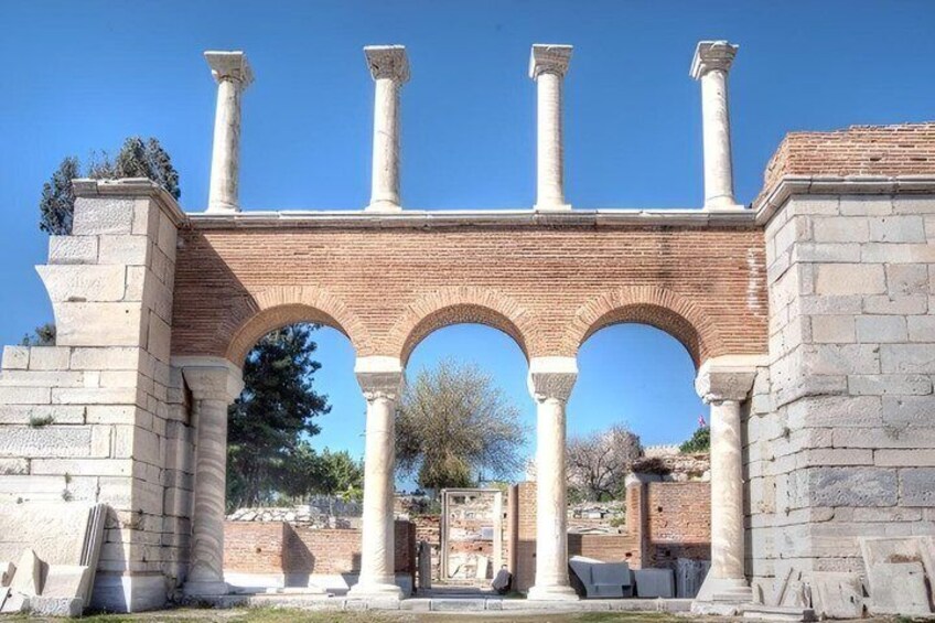An ancient stone archway with columns and a brick base. 5