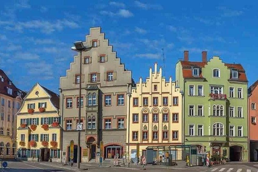 A street with colorful buildings, a clear blue sky, and a pedestrian crossing. 2