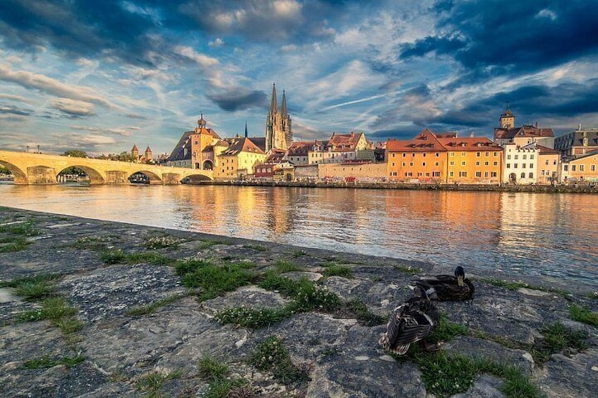 A river with ducks, a bridge, and historic buildings. 1