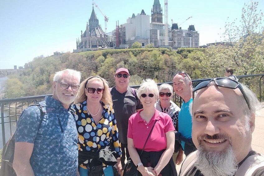A group of people standing on a bridge with a cityscape in the background. 4