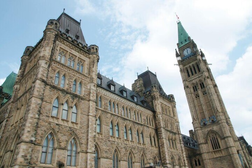 A historic building with Gothic architecture, including pointed arches and a clock tower. 1
