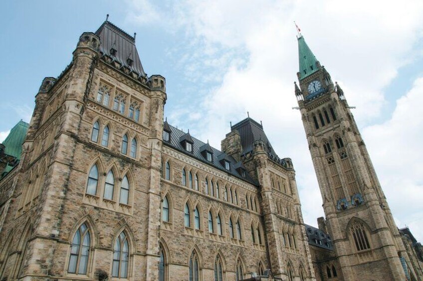 A historic building with Gothic architecture, including pointed arches and a clock tower. 2
