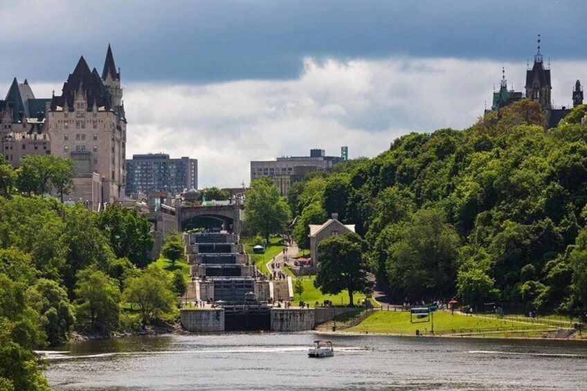 A river with a boat, a castle-like building, and a park with stairs leading to a bridge. 3