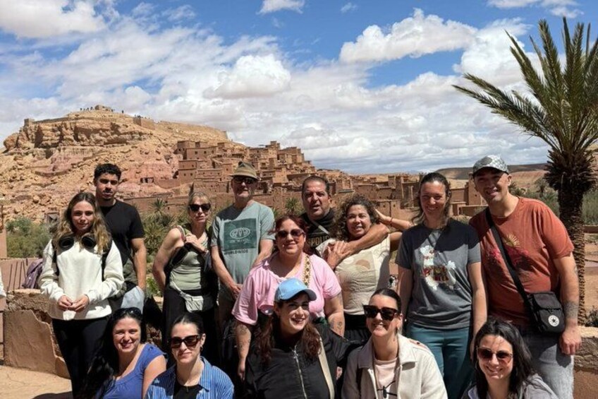 Un grupo de personas posando frente a ruinas antiguas bajo un cielo despejado. 5