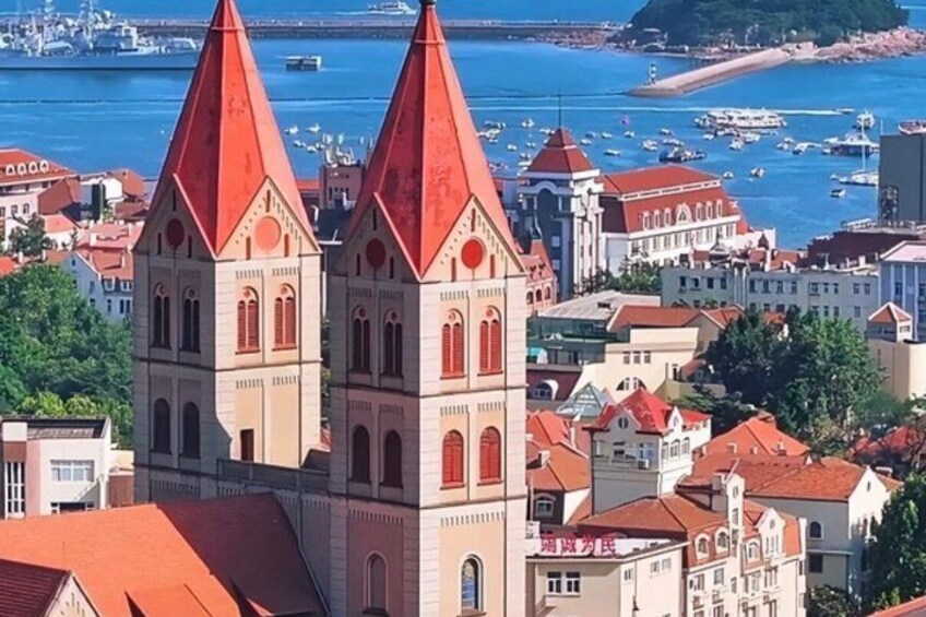 A coastal cityscape with prominent red-roofed towers and a marina filled with boats. 5
