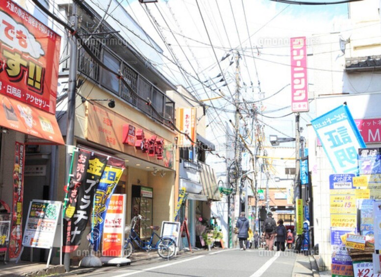 A street with various shops, signs, and a bicycle. 5