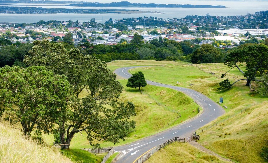 A winding road through a hilly landscape with a town in the background. 2