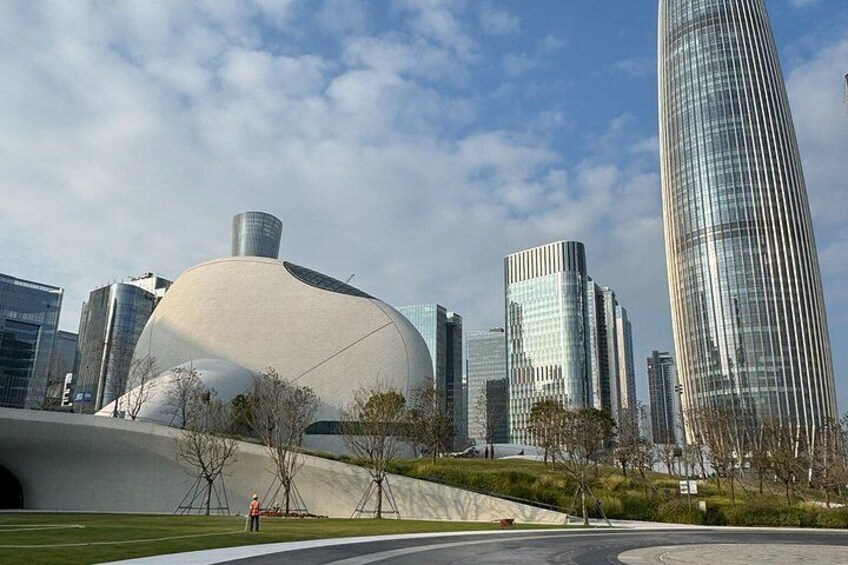 A modern cityscape with a unique dome-shaped building and a tall skyscraper. 4