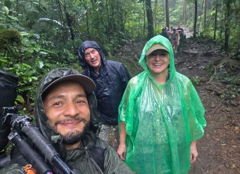 A group of people in a forested area with a camera and equipment on the ground. 5