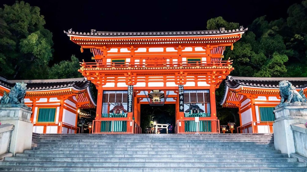 A traditional Japanese torii gate with a staircase leading up to it, surrounded by trees. 1