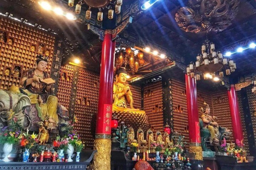A temple interior with statues, red pillars, and ornate decorations. 5