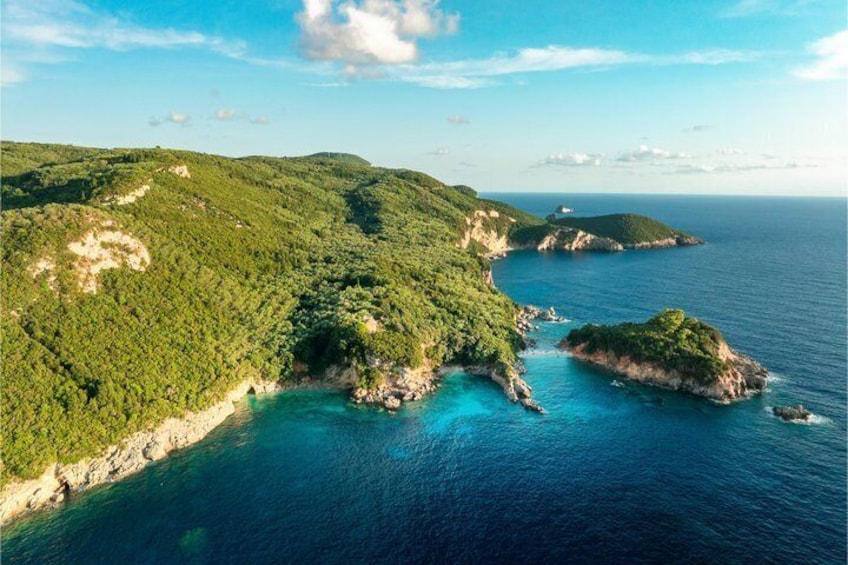 A coastal landscape with lush green hills, clear blue waters, and small islands. 2