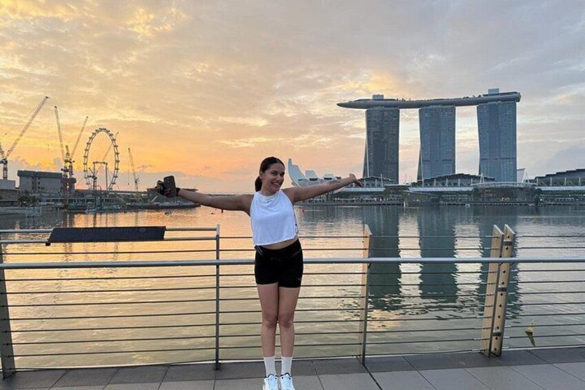 A person standing on a waterfront with a city skyline in the background. 5