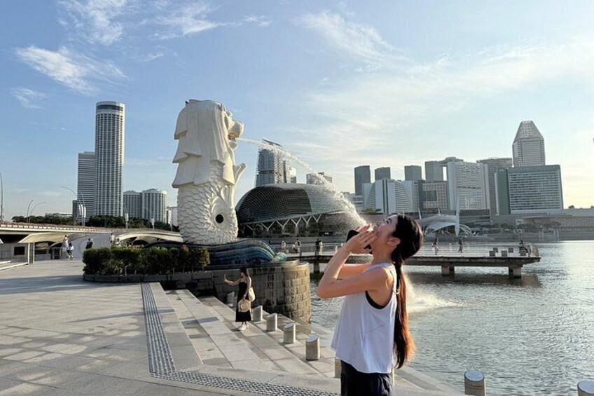 A cityscape with modern buildings, a large white statue, and a waterfront. 3