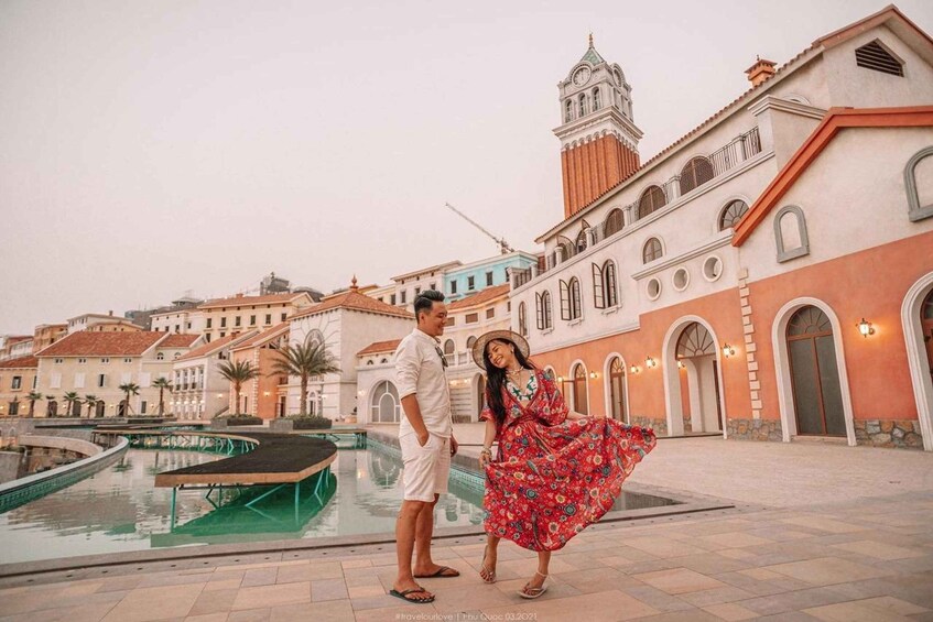 A couple by a pool with historic buildings in the background. 2