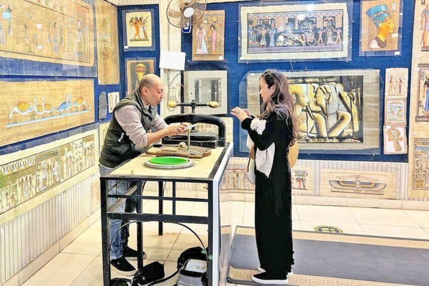 An indoor museum with Egyptian wall art and a person examining an artifact. 3