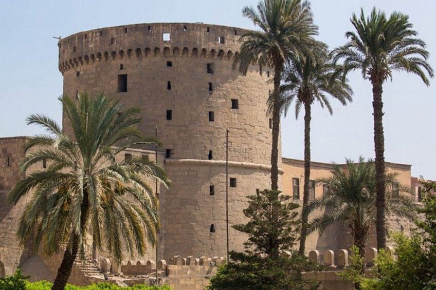 A historic stone tower with palm trees in the foreground. 4