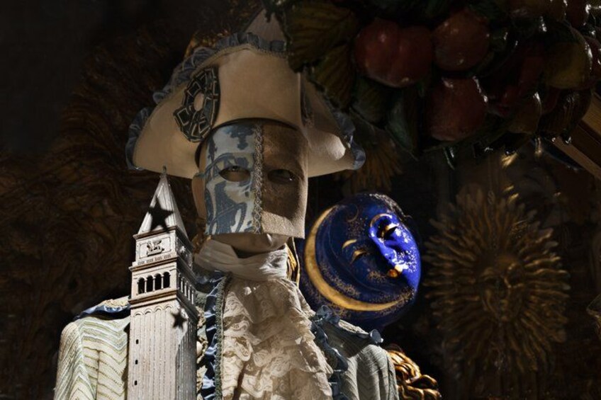 A statue with a large hat, a blue and gold sphere, and a building in the background. 4