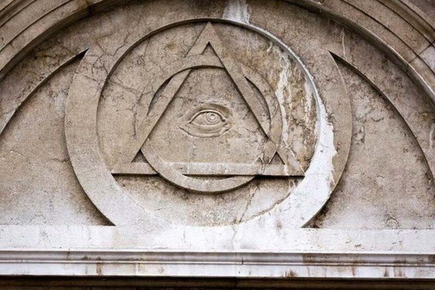 A stone relief with a triangle, eye, and crescent moon. 3