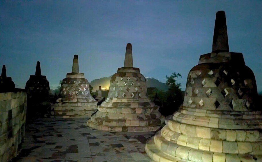 A series of stone stupas with a pathway leading towards them. 2